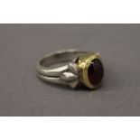 An unmarked gold and silver garnet ring. Ring size L.