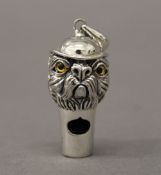 A silver whistle formed as a dog. 3.5 cm high.