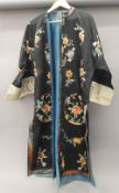 A Chinese silk robe with black background and floral roundels.