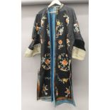 A Chinese silk robe with black background and floral roundels.