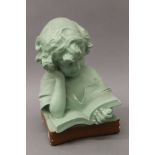 An early 20th century green painted plaster bust of a young girl reading. 33 cm high.