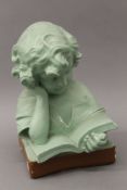 An early 20th century green painted plaster bust of a young girl reading. 33 cm high.