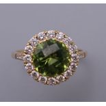 An 18 ct gold, peridot and diamond ring with diamond shoulders. Ring Size M. 3.