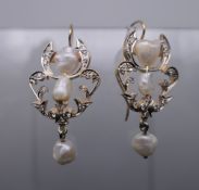 A pair of unmarked gold and pearl earrings. 3 cm high.