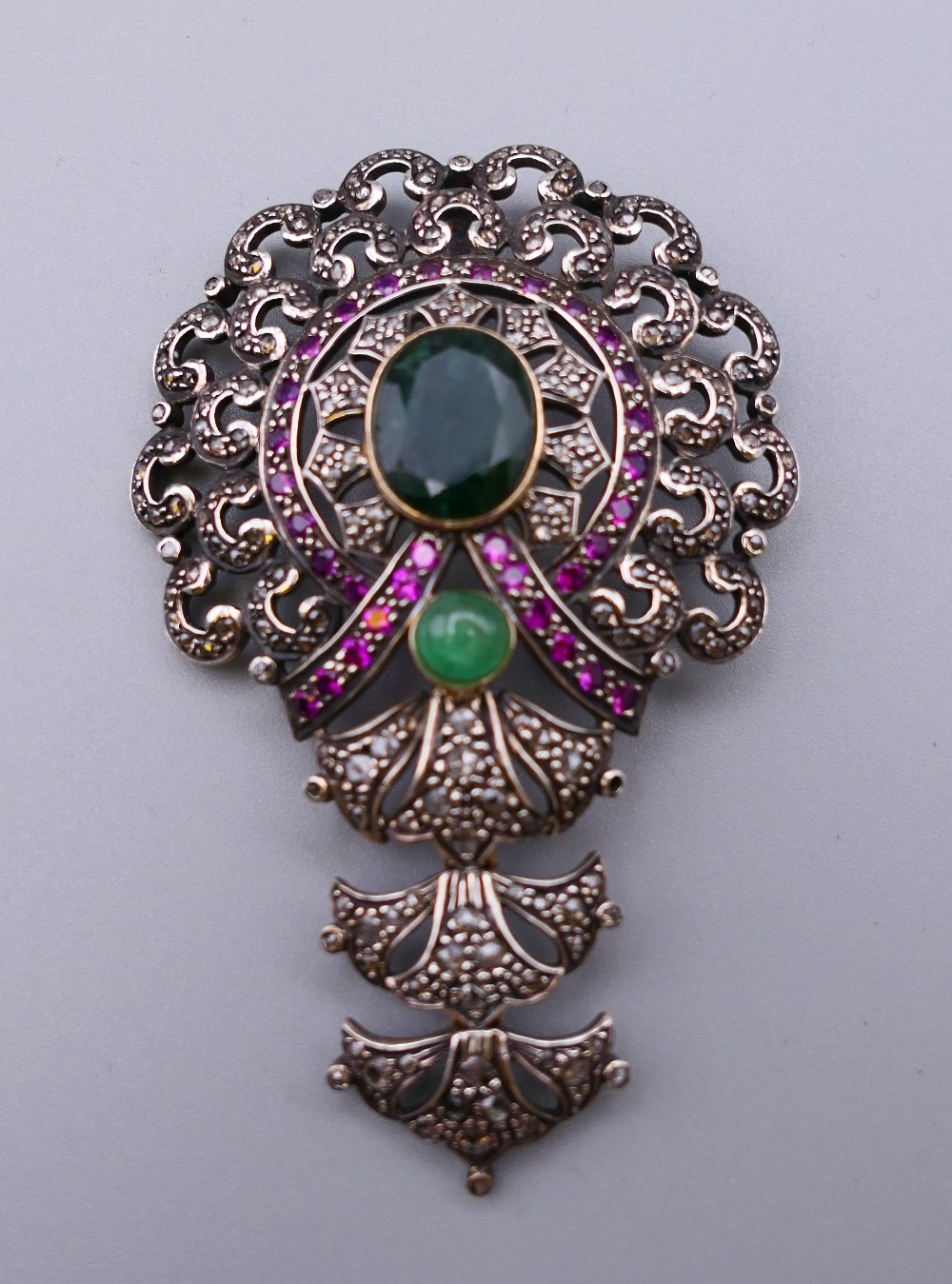 A vintage silver and gold mounted emerald, diamond and ruby pendant. 7.5 cm high. 21.