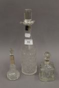 A silver collared decanter and two silver collared scent bottles. The former 28.5 cm high.
