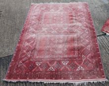 A red ground rug. 236 x 159 cm.