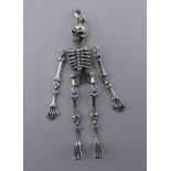 A skeleton form pendant. 8 cm high.