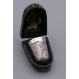 A silver thimble, in a leather case. 3.75 cm high.