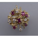 A Contemporary 18 ct gold ruby and diamond cluster ring. Ring size O. 14.2 grammes total weight.