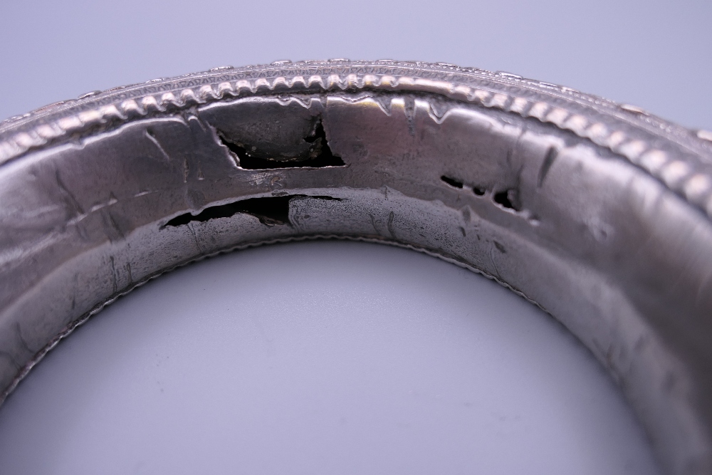 Three Eastern white metal bangles, two probably unmarked silver. The largest 12.5 cm diameter. - Image 11 of 14