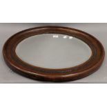 An early 20th century oval wall mirror. 63.5 cm wide.