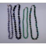 An agate facet cut bead necklace, a jade bead necklace and two others. The former 45 cm long.