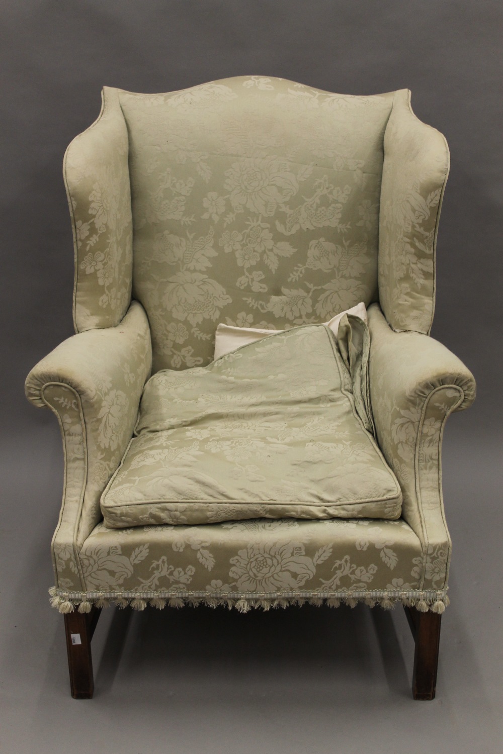 An early 20th century upholstered wing back armchair. 80 cm wide.