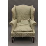 An early 20th century upholstered wing back armchair. 80 cm wide.