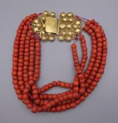 A string of coral beads with an unmarked 18 ct gold clasp. 37 cm long.