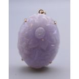 A 14 ct gold and carved lavender jade pendant. 4 cm high.