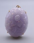 A 14 ct gold and carved lavender jade pendant. 4 cm high.
