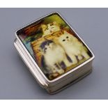 A silver pill box depicting cats. 3 cm high.