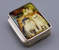 A silver pill box depicting cats. 3 cm high.