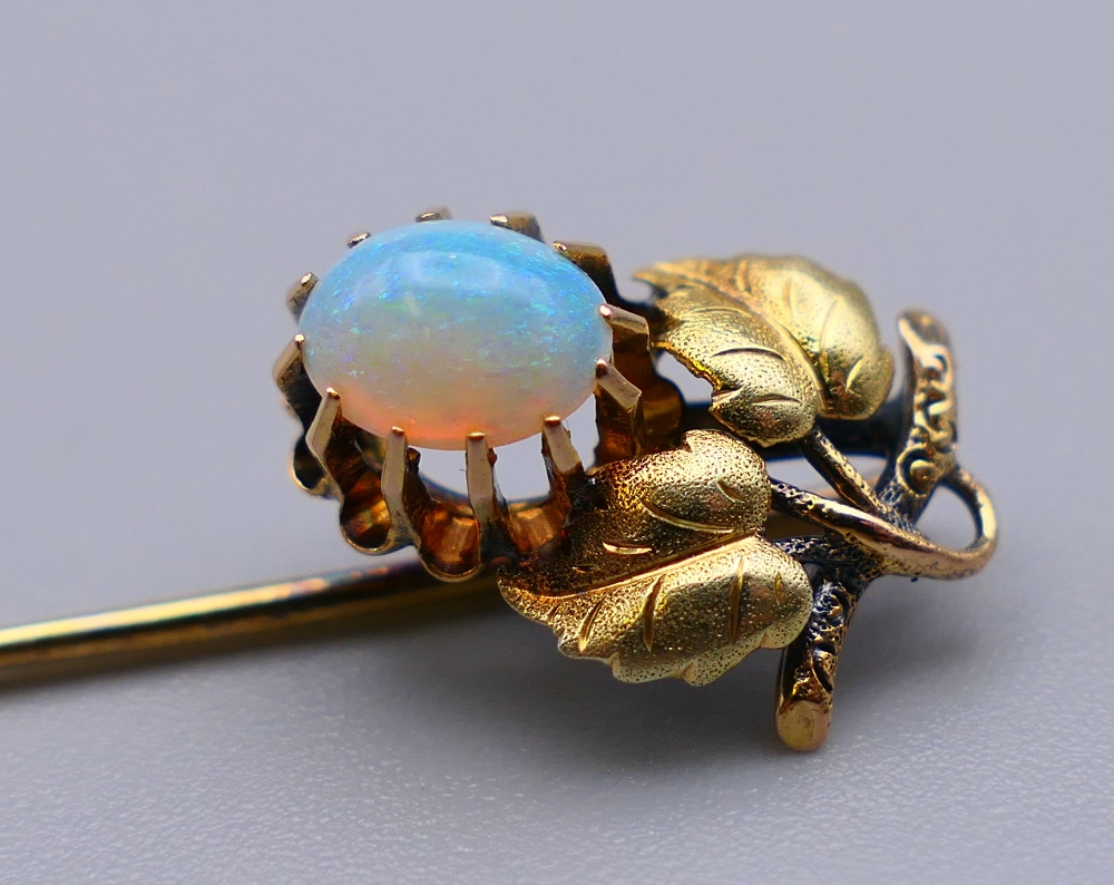 An unmarked gold and opal stick pin. 6 cm high. 1.9 grammes total weight. - Image 3 of 4