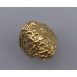 An unmarked 18 ct gold ring of textured form. Ring size L. 12.8 grammes.