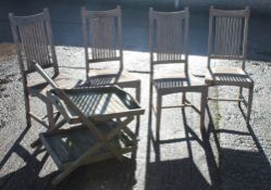 A set of four teak garden chairs and a drinks trolley.