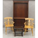 A modern bookcase, a white painted cupboard, a box stool and a pair of modern chairs.