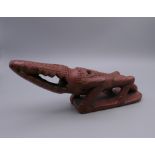 An Egyptian red ware bath rasp, formed as a crocodile. 20 cm long.