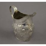 An embossed Georgian silver cream jug. 9.5 cm high. 2.7 troy ounces.