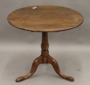 A Georgian oak tilt top tripod table. 77 cm diameter.