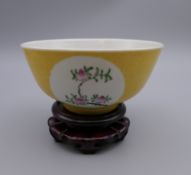 A Chinese yellow ground porcelain bowl on stand. 11 cm diameter.