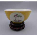 A Chinese yellow ground porcelain bowl on stand. 11 cm diameter.