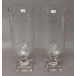 A pair of glass hurricane lamps. 34 cm high.
