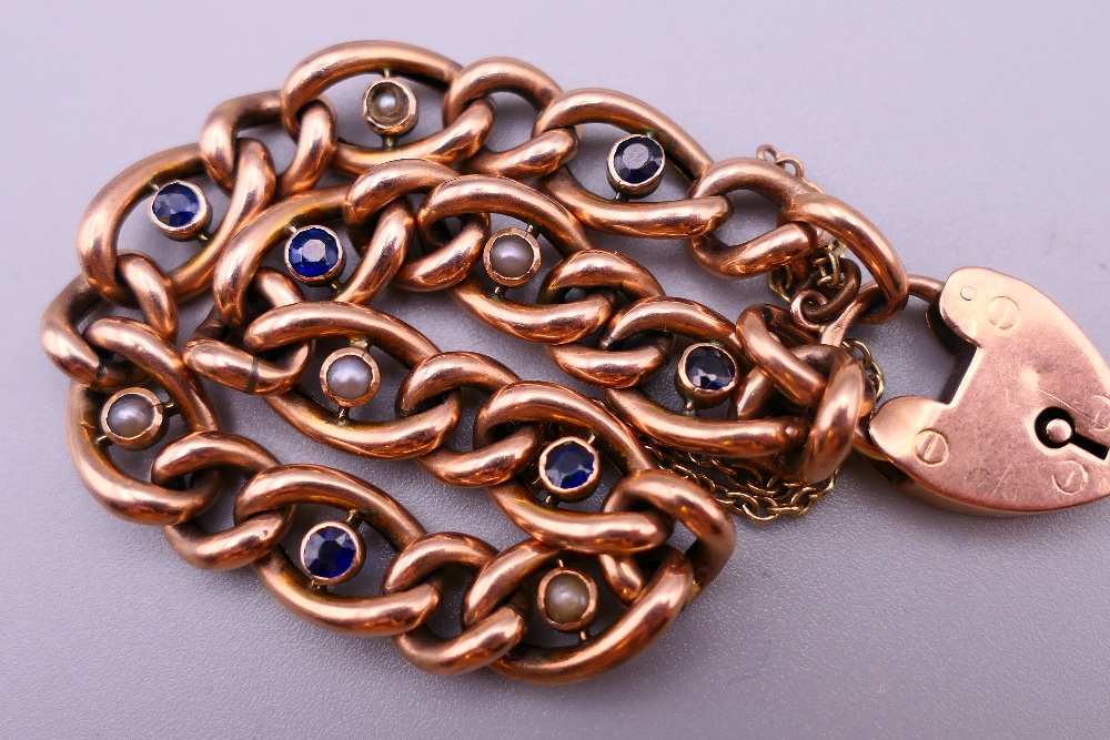 A 9 ct gold seed pearl and sapphire set bracelet with a 9 ct gold padlock. 19 cm long. 12. - Image 4 of 6