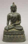 A small bronze figure of a seated deity. 15 cm high.
