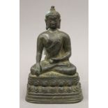 A small bronze figure of a seated deity. 15 cm high.