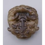 An archaic style green jade roundel pendant. 5 cm high.