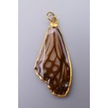 An unmarked high ct gold set pendant formed as a butterfly wing. 4.5 cm high.