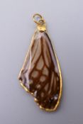 An unmarked high ct gold set pendant formed as a butterfly wing. 4.5 cm high.