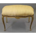 An upholstered gilt stool. 90 cm wide.