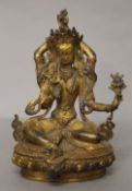 A gilt bronze deity with coral and turquoise. 21.5 cm high.