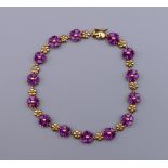 A 9 ct gold heart shape garnet bracelet. 18 cm long. 8.1 grammes total weight.