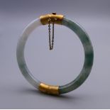 A 14 ct gold and jade bangle. 7 cm diameter.