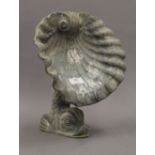 A lead garden ornament, modelled as a dolphin with a clam shell. 31 cm high.