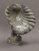 A lead garden ornament, modelled as a dolphin with a clam shell. 31 cm high.