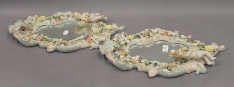 A pair of Continental porcelain florally encrusted and figural wall mirrors. 46 cm high.