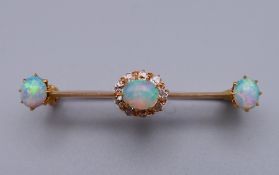An unmarked gold diamond and opal bar brooch. 4 cm wide. 3 grammes total weight.