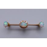 An unmarked gold diamond and opal bar brooch. 4 cm wide. 3 grammes total weight.