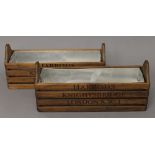 A pair of wooden troughs inscribed Harrods. 35 cm long.